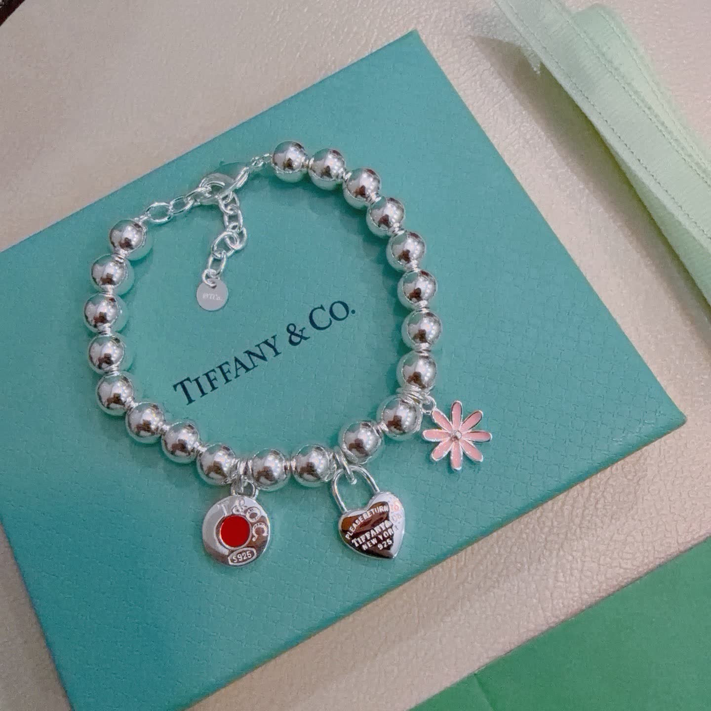 Tiffany & Co. Sterling Silver Bead Bracelet with Lock and Flower Charms